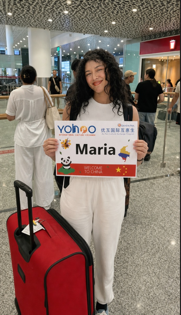 Maria arriving with luggage and a Yohoo welcome board