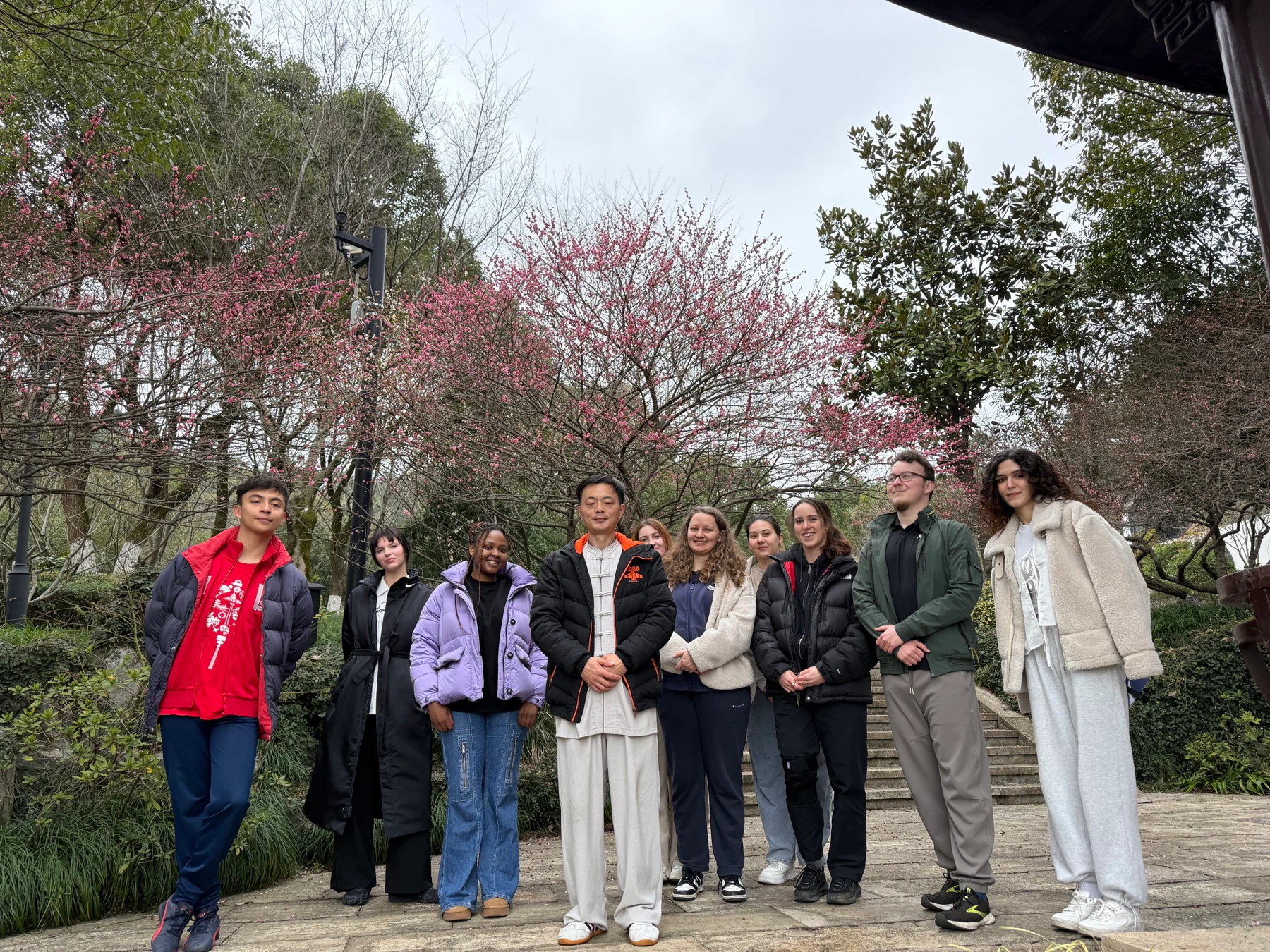 Yohoo au pairs joining a tai chi cultural activity among spring blossoms in Hangzhou